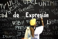 A student writes a graffiti on a wall as
