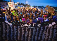 Protestors march and hold their fists aloft as they march during ongoing demonstrations in reaction to the shooting of Michael Brown in Ferguson, Missouri